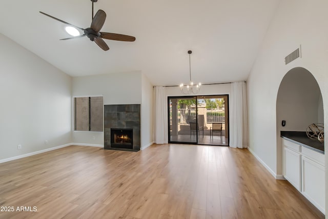 18818 N 95th Ave, Peoria, AZ 85382 - unfurnished living room featuring a tiled fireplace, baseboards, light wood-style floors, and visible vents