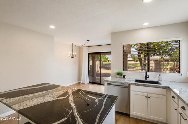 18818 N 95th Ave, Peoria, AZ 85382 - kitchen featuring a sink, white cabinetry, light stone countertops, dishwasher, and light wood-style floors