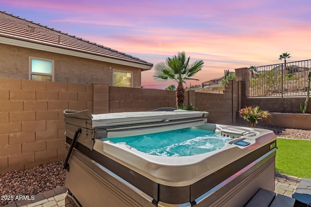 view of swimming pool featuring a hot tub and a fenced backyard