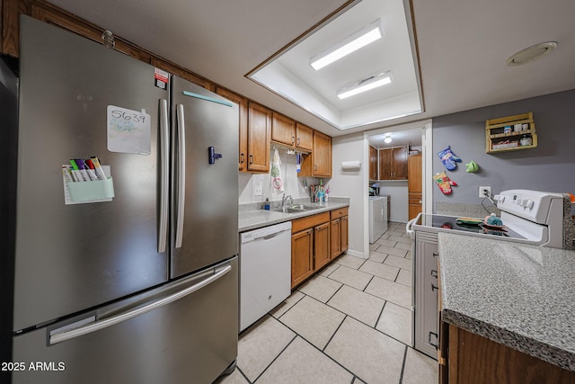 4623 W Solano Dr S S, Unit South, Glendale, AZ 85301 - kitchen with white appliances, washing machine and clothes dryer, light tile patterned floors, brown cabinetry, and a raised ceiling