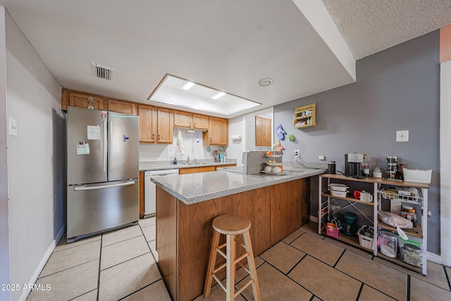 4623 W Solano Dr S S, Unit South, Glendale, AZ 85301 - kitchen featuring freestanding refrigerator, dishwashing machine, a peninsula, light tile patterned floors, and a raised ceiling