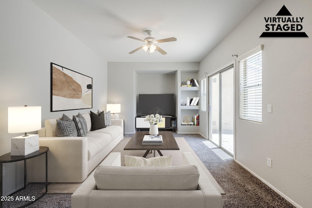 14881 W Ashland Ave, Goodyear, AZ 85395 - carpeted living room featuring ceiling fan, built in shelves, and baseboards