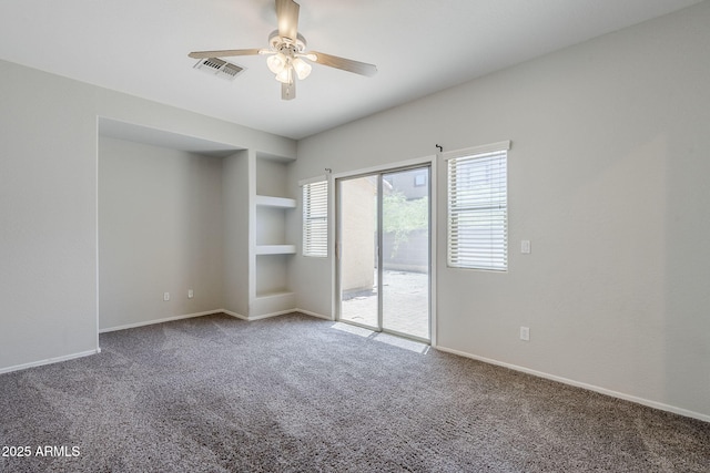 14881 W Ashland Ave, Goodyear, AZ 85395 - carpeted empty room featuring ceiling fan, built in shelves, and baseboards