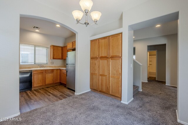 14881 W Ashland Ave, Goodyear, AZ 85395 - kitchen featuring black dishwasher, freestanding refrigerator, dark colored carpet, a sink, and a chandelier