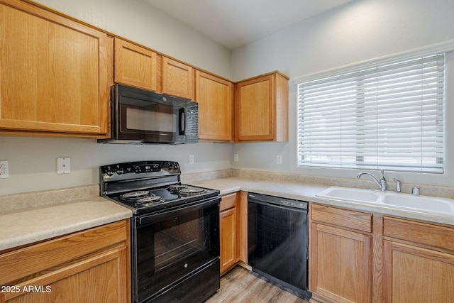 14881 W Ashland Ave, Goodyear, AZ 85395 - kitchen featuring black appliances, a sink, light wood finished floors, and light countertops