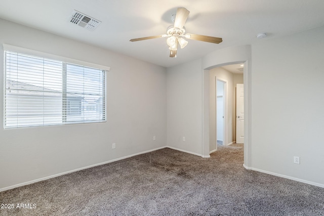 14881 W Ashland Ave, Goodyear, AZ 85395 - unfurnished room featuring arched walkways, ceiling fan, carpet, and baseboards