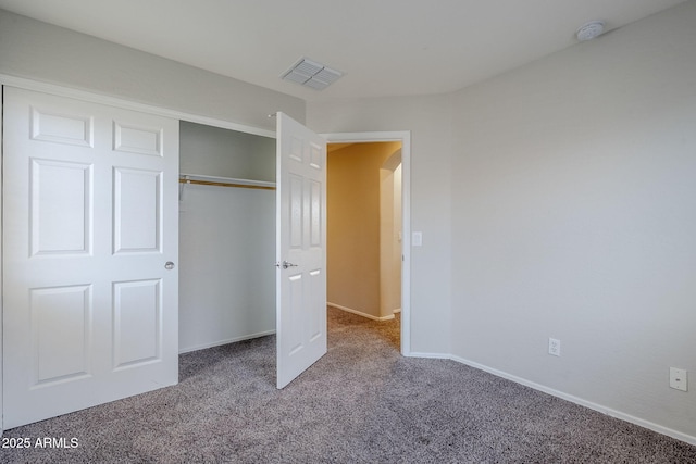 14881 W Ashland Ave, Goodyear, AZ 85395 - unfurnished bedroom with carpet flooring, arched walkways, baseboards, and a closet