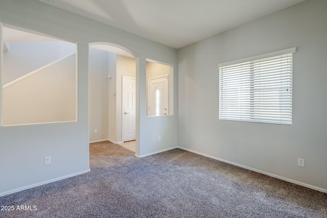 14881 W Ashland Ave, Goodyear, AZ 85395 - spare room featuring arched walkways, carpet, and baseboards