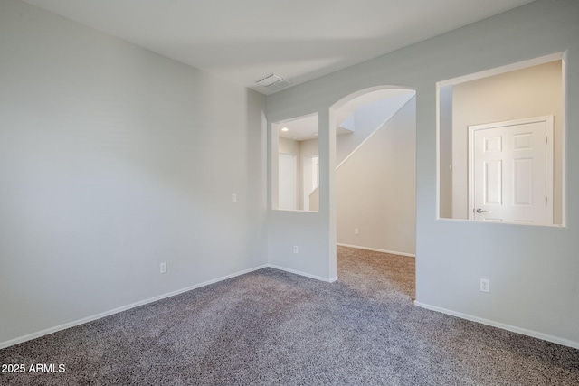 14881 W Ashland Ave, Goodyear, AZ 85395 - empty room with carpet, baseboards, and arched walkways