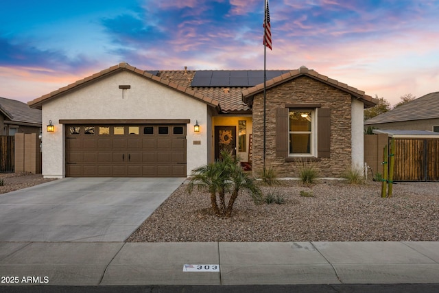 view of front facade with concrete driveway, stone siding, an attached garage, roof mounted solar panels, and stucco siding