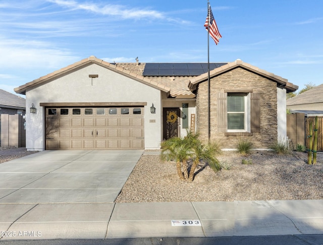 ranch-style house featuring stone siding, a tile roof, an attached garage, roof mounted solar panels, and stucco siding