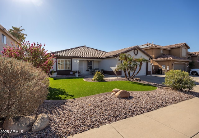 mediterranean / spanish house featuring a garage and a front yard