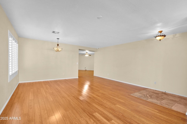 unfurnished room featuring light hardwood / wood-style flooring and a notable chandelier