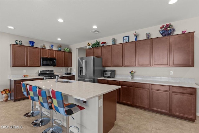 22912 E Domingo Rd, Queen Creek, AZ 85142 - kitchen with stainless steel appliances, a sink, a center island with sink, recessed lighting, and a breakfast bar