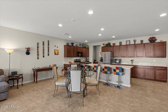 22912 E Domingo Rd, Queen Creek, AZ 85142 - kitchen featuring recessed lighting, an island with sink, light countertops, a breakfast bar, and appliances with stainless steel finishes