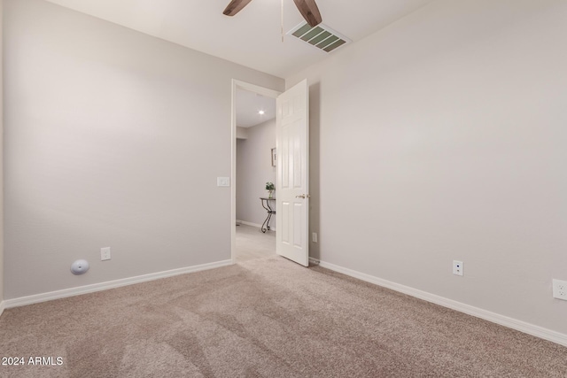 unfurnished room with light colored carpet and ceiling fan