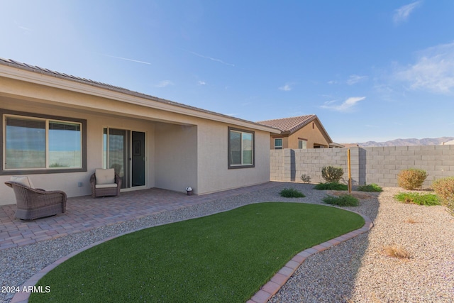 rear view of house featuring a yard and a patio