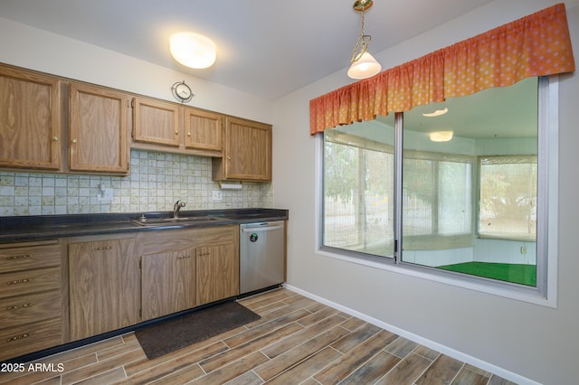 19417 N Palo Verde Dr, Sun City, AZ 85373 - kitchen with decorative backsplash, dark countertops, wood tiled floor, a sink, and stainless steel dishwasher