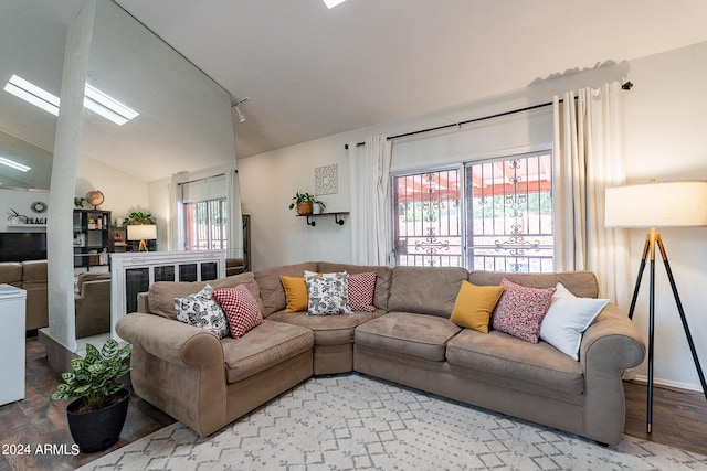 living room featuring a wealth of natural light, vaulted ceiling, and hardwood / wood-style flooring