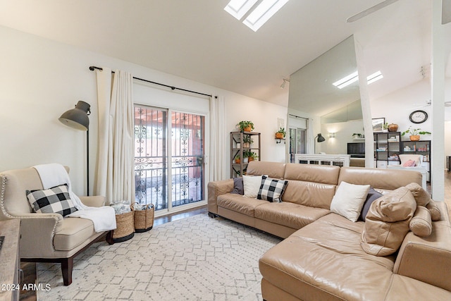 living room with vaulted ceiling with skylight