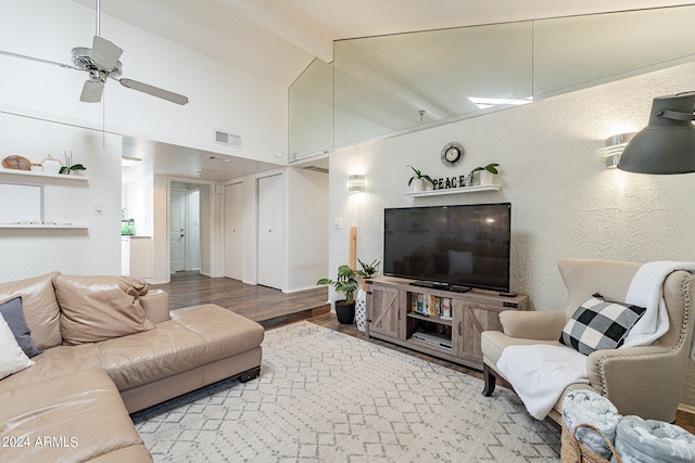 living room featuring ceiling fan, hardwood / wood-style floors, and beamed ceiling