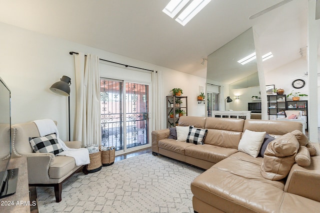 living room featuring high vaulted ceiling and a skylight