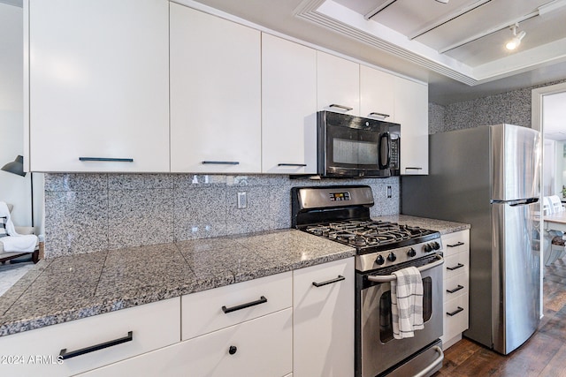 kitchen with dark wood-type flooring, tasteful backsplash, a raised ceiling, stainless steel appliances, and white cabinets