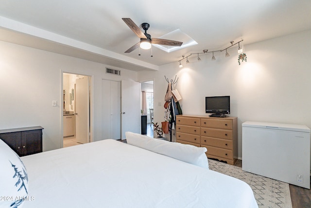 bedroom with a closet, light hardwood / wood-style floors, connected bathroom, ceiling fan, and fridge