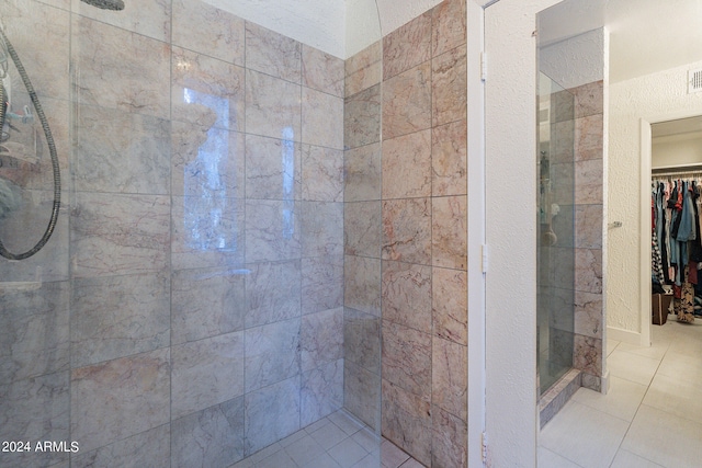 bathroom with tile patterned flooring and tiled shower