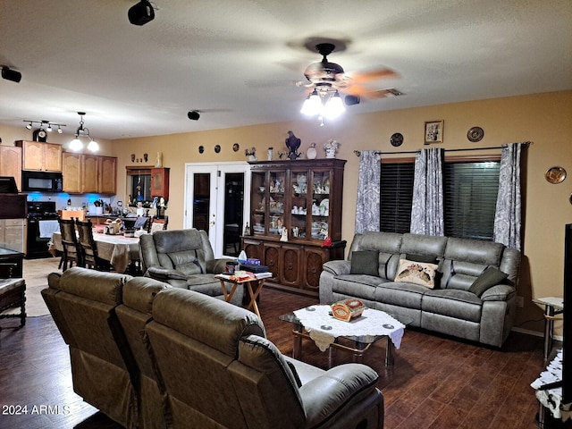 living room with ceiling fan and dark wood-type flooring