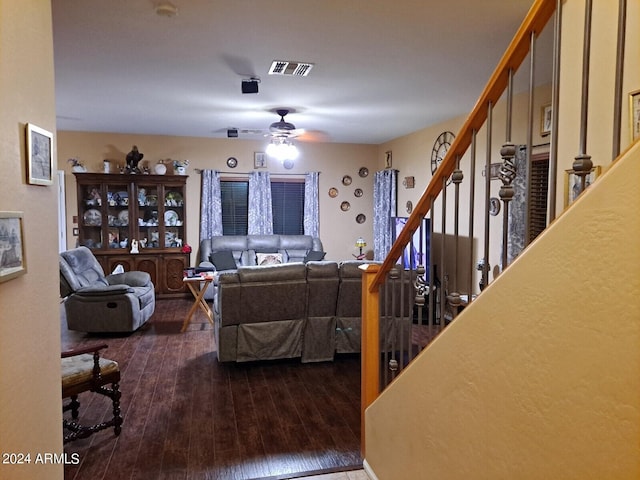 living room featuring ceiling fan and dark wood-type flooring