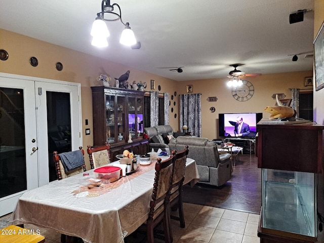 tiled dining room featuring ceiling fan with notable chandelier and french doors