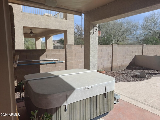 view of patio featuring ceiling fan and a hot tub