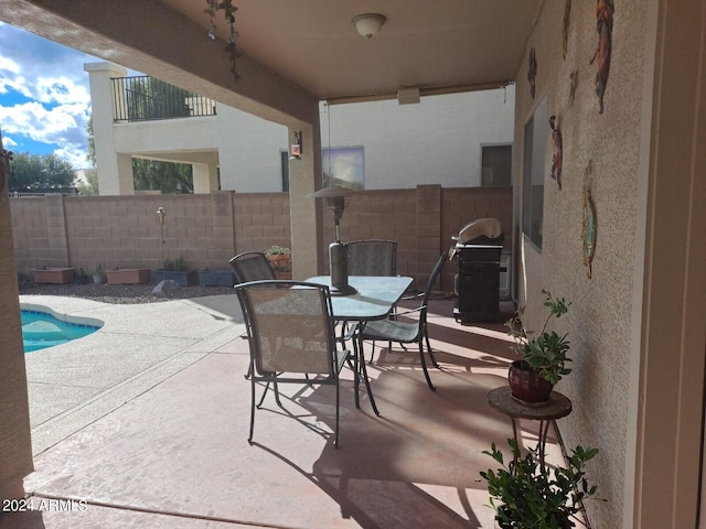 view of patio featuring a fenced in pool and a grill