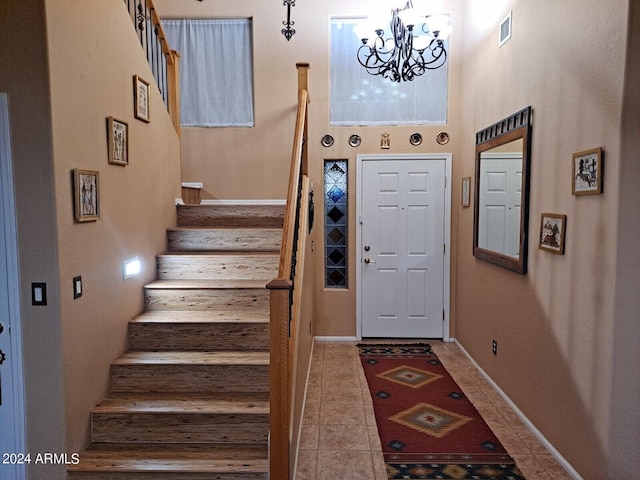 foyer with an inviting chandelier, a high ceiling, and tile patterned floors