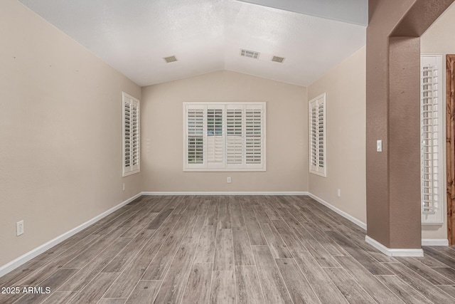 3028 W Parkside Ln, Phoenix, AZ 85027 - spare room featuring wood finished floors, lofted ceiling, and baseboards