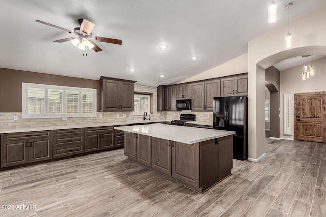 3028 W Parkside Ln, Phoenix, AZ 85027 - kitchen with black appliances, arched walkways, dark brown cabinetry, light countertops, and tasteful backsplash