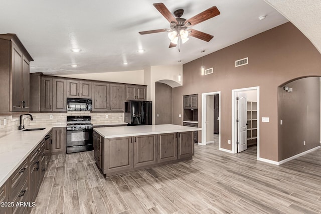 3028 W Parkside Ln, Phoenix, AZ 85027 - kitchen featuring black appliances, arched walkways, a sink, a ceiling fan, and a kitchen island