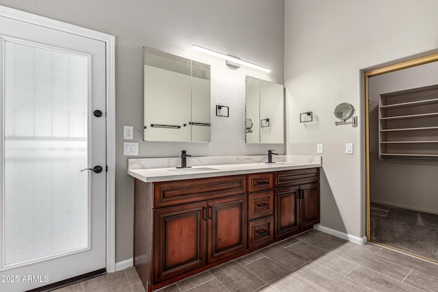 3028 W Parkside Ln, Phoenix, AZ 85027 - bathroom featuring double vanity, baseboards, and a walk in closet