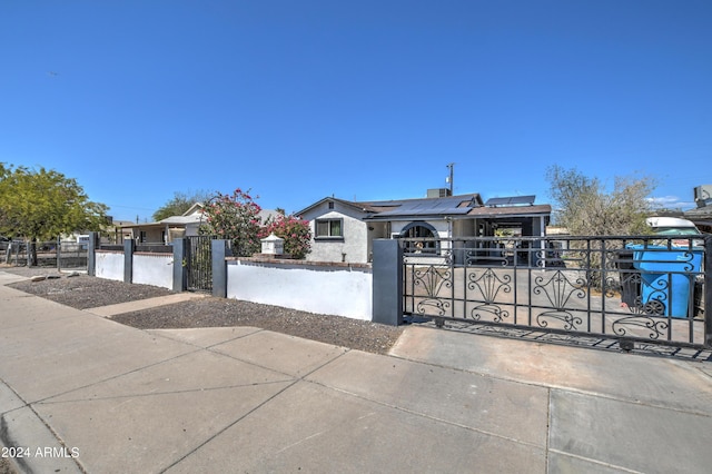 2124 W Maricopa St, Phoenix, AZ 85009 - view of front of house featuring solar panels, a fenced front yard, and a gate