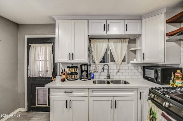 2124 W Maricopa St, Phoenix, AZ 85009 - kitchen with a sink, black microwave, open shelves, white cabinets, and light countertops