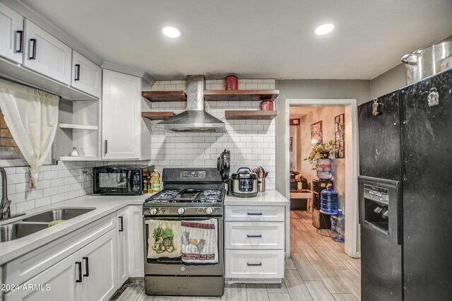 2124 W Maricopa St, Phoenix, AZ 85009 - kitchen with open shelves, black appliances, wall chimney exhaust hood, white cabinetry, and a sink
