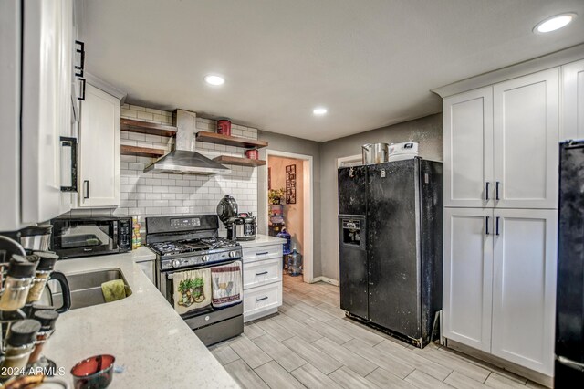 2124 W Maricopa St, Phoenix, AZ 85009 - kitchen with black appliances, wall chimney exhaust hood, tasteful backsplash, white cabinets, and recessed lighting