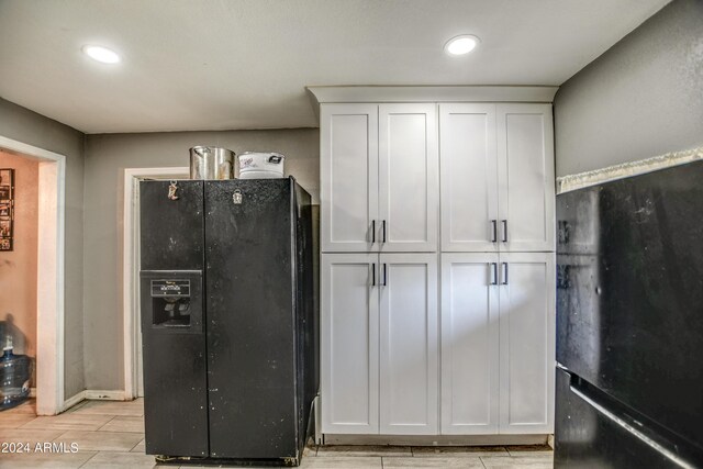 2124 W Maricopa St, Phoenix, AZ 85009 - kitchen featuring black fridge, freestanding refrigerator, white cabinetry, recessed lighting, and wood tiled floors