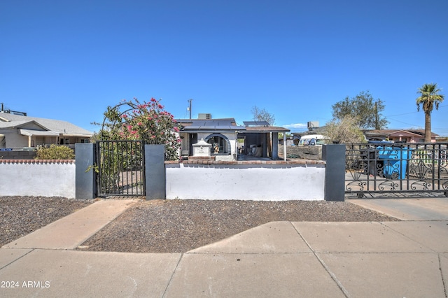 2124 W Maricopa St, Phoenix, AZ 85009 - view of property hidden behind natural elements with a gate, a fenced front yard, and roof mounted solar panels