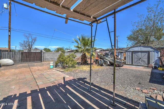 2124 W Maricopa St, Phoenix, AZ 85009 - view of patio featuring a storage shed, fence, and an outbuilding