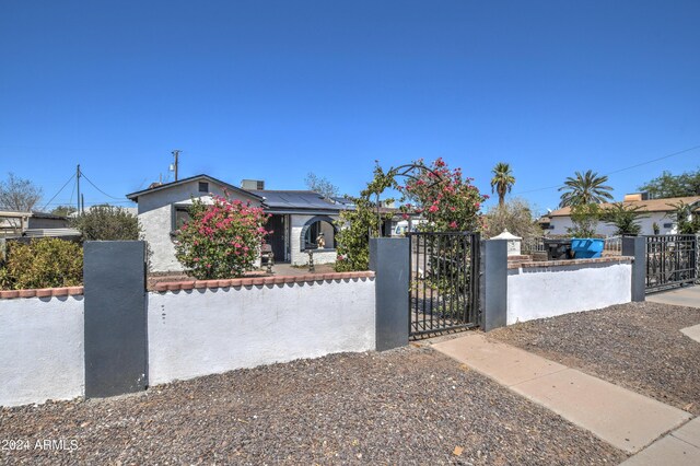 2124 W Maricopa St, Phoenix, AZ 85009 - view of front of property with a fenced front yard, a gate, and solar panels