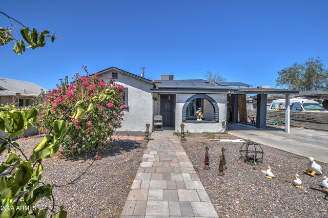2124 W Maricopa St, Phoenix, AZ 85009 - view of front of house with solar panels, stucco siding, and a carport