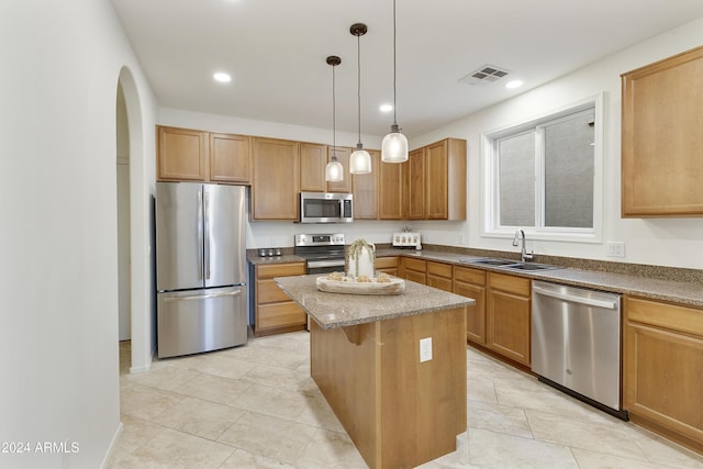 kitchen featuring sink, a kitchen island, pendant lighting, light tile patterned flooring, and appliances with stainless steel finishes