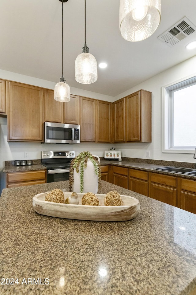 kitchen featuring hanging light fixtures, sink, and appliances with stainless steel finishes